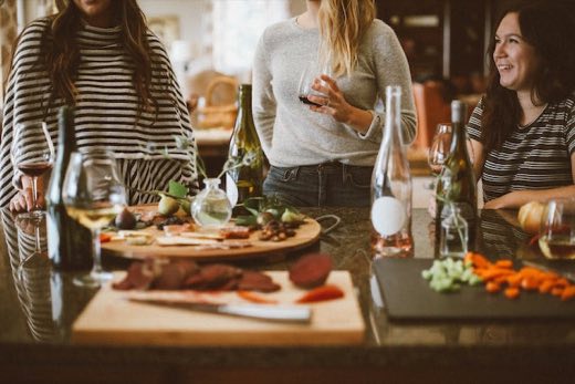 Friends gathered around wine and a charcuterie board